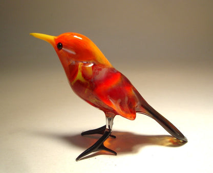 Side view of the glass red bird figurine, highlighting the color of the body in different shades of red.