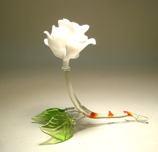 A side angle of a white glass rose figurine, highlighting the graceful curves of the stem and leaves. 