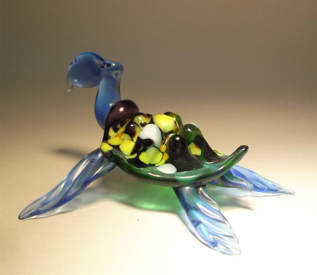 glass blue sea turtle figurine with yellow and orange specs on its shell