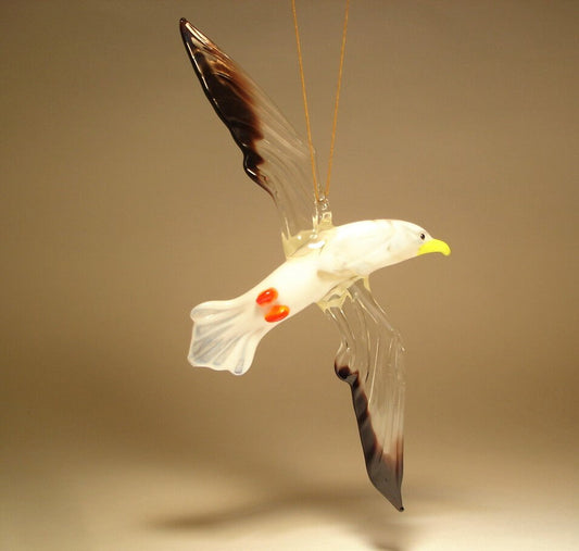 A side view of a glass hanging seagull albatross ornament figurine, showcasing its detailed wings and sleek body, suspended delicately with a string.