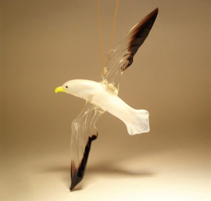 Another side view of a glass hanging seagull albatross ornament figurine with a yellow beak. 