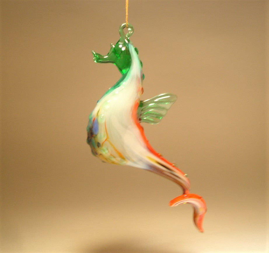 The hanging seahorse ornament is shown from a different view with its red and white its curved tail.