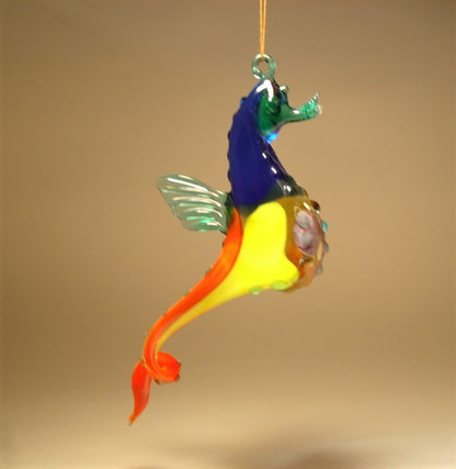 Another side view of the glass hanging seahorse ornament, showcasing its red and yellow colors and curled tail.