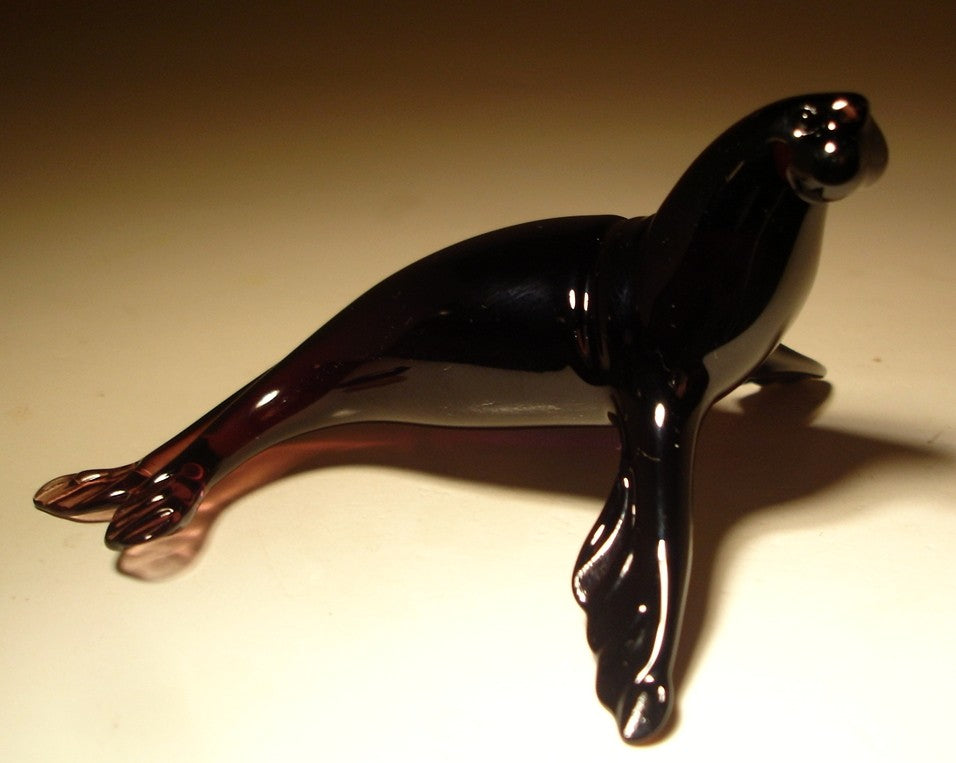 Handmade dark purple glass seal figurine raised on its flippers