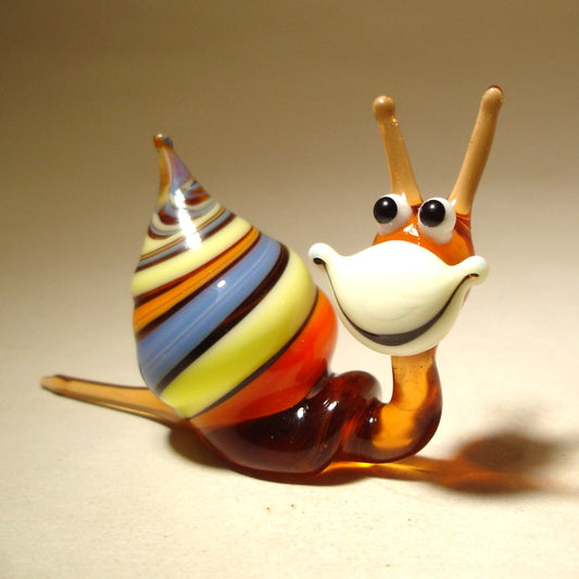 A close-up of a comical Glass Happy Snail Figurine smiling.