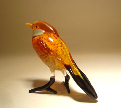 Back view of the glass sparrow figurine, highlighting the delicate design of its wings and black tail.