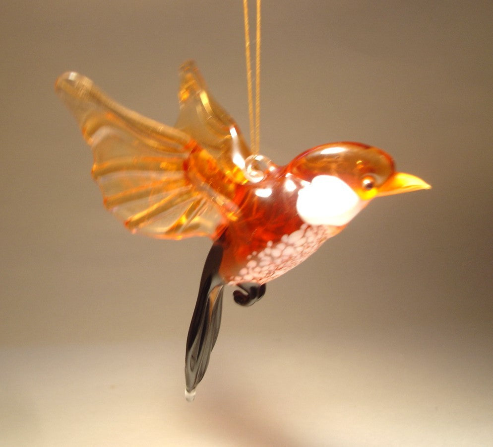 Another side view of a glass sparrow ornament figurine, emphasizing the smooth curves of its body and the detailed tail feathers.