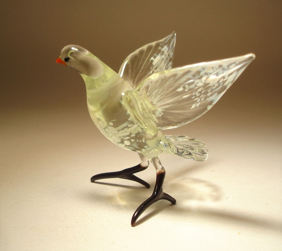 A close-up shot of the white and clear glass dove figurine, focusing on the delicate craftsmanship of its beak and eyes. 