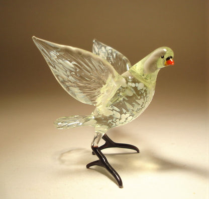 A side view of the white and clear glass pigeon dove figurine, highlighting its poised stance with semi open wings.