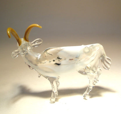 A back side of the handmade glass goat figurine showing the intricate details of its fur, ears and tail made out of clear glass.