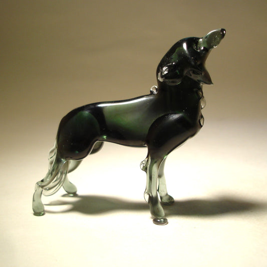 A front view of a grey glass wolf figurine in a howling pose, showcasing its raised head.