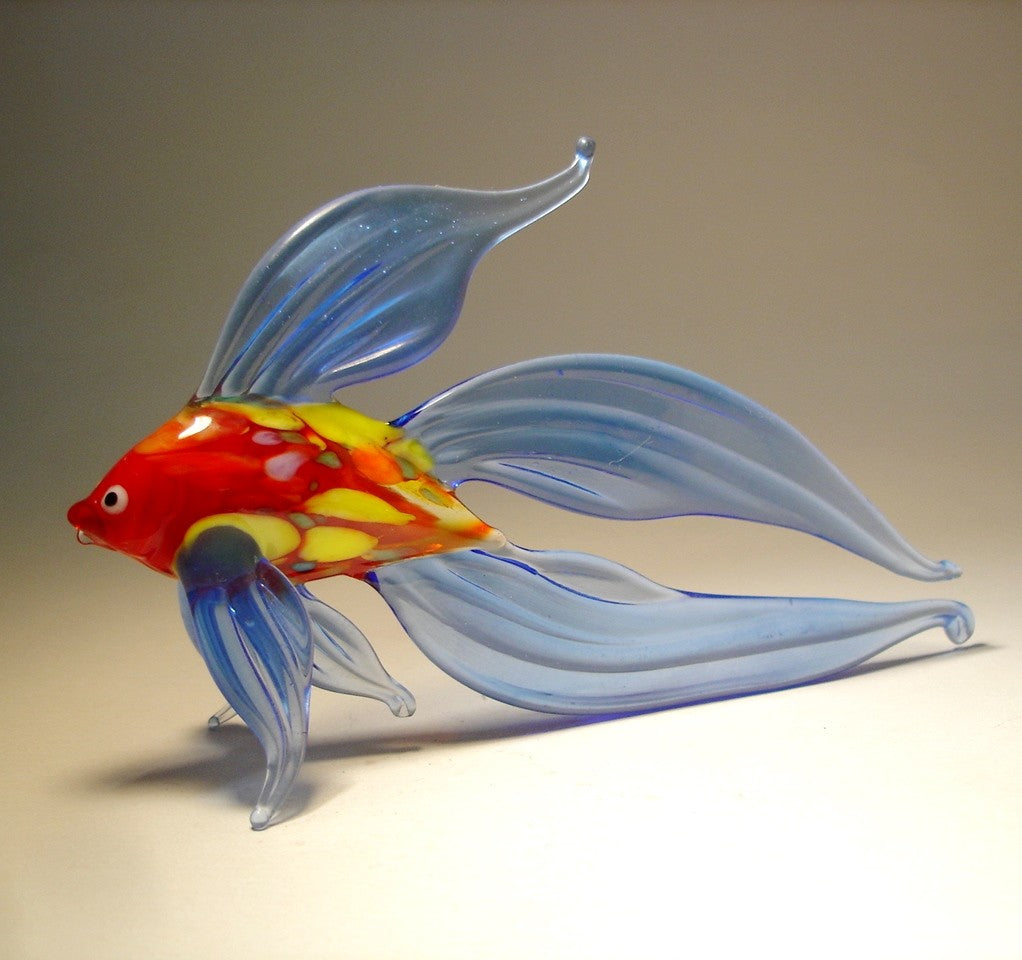 left side view of a blue glass betta fish figurine, showcasing its flowing blue fins and red and yellow body