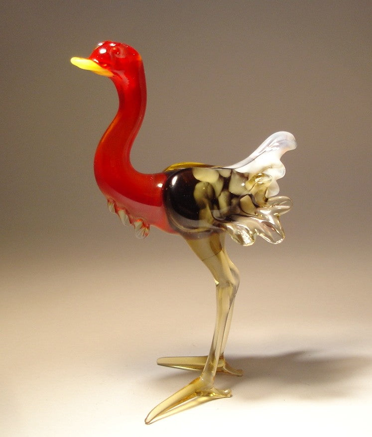 Side view of the glass ostrich, showcasing its elegant posture and the vibrant contrast between the brown and white body and the bold red neck. 